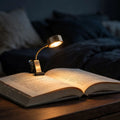 Clip-on warm reading light glowing on book at night
