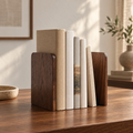 Solid walnut bookends holding neutral books in a warm reading room